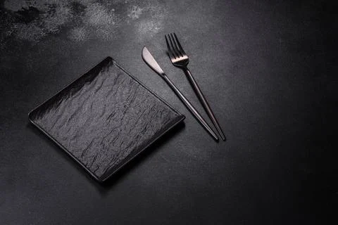 Empty square black plate on dark moody background with copy space Stock Photos