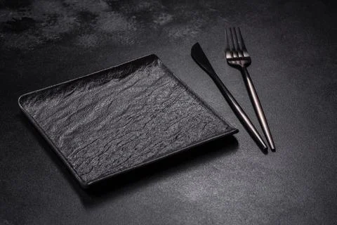 Empty square black plate on dark moody background with copy space Stock Photos
