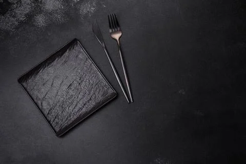 Empty square black plate on dark moody background with copy space Foto stock