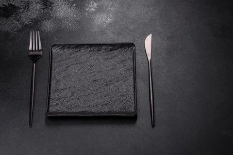 Empty square black plate on dark moody background with copy space Stock Photos