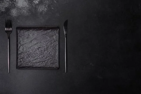 Empty square black plate on dark moody background with copy space Foto stock