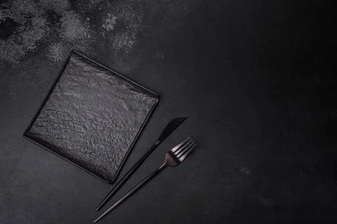 Empty square black plate on dark moody background with copy space Foto stock