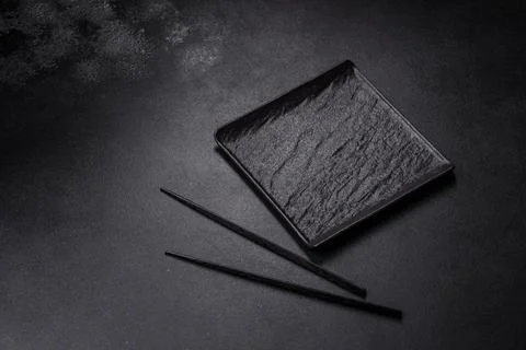 Empty square black plate on dark moody background with copy space Stock Photos