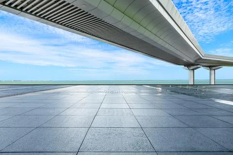Empty square floor and bridge with river under blue sky. Stock Photos