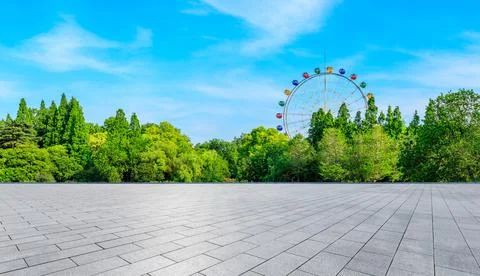 Empty square floor and ferris wheel with green forest landscape. Stock Photos