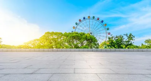 Empty square floor and ferris wheel with green forest landscape. Stock Photos