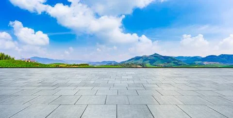 Empty square floor and green tea garden under blue sky. Stock Photos