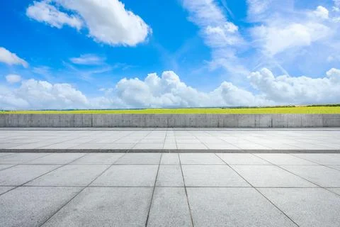 Empty square floor and green field nature landscape under blue sky. Stock Photos