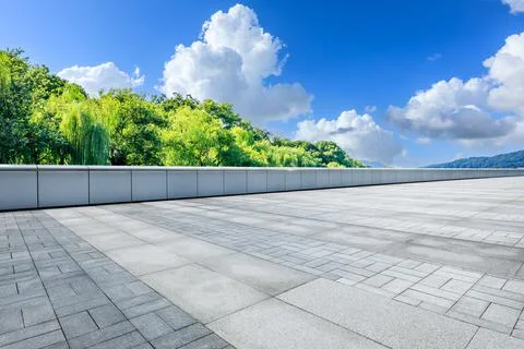 Empty square floor and green forest with mountain scenery under blue sky. Stock Photos