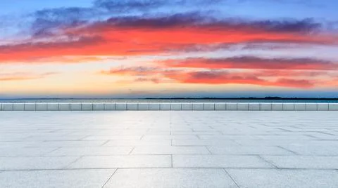 Empty square floor and lake with beautiful clouds at sunset. Stock Photos
