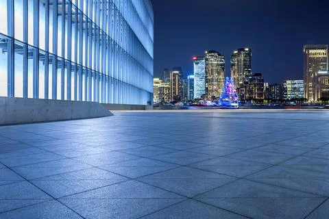 Empty square floor and modern city buildings in Shanghai at night. Stock Photos