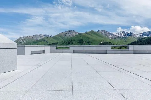 Empty square floor and mountains under blue sky. Stock Photos