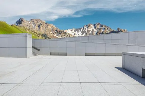 Empty square floor and mountains under blue sky. Stock Photos