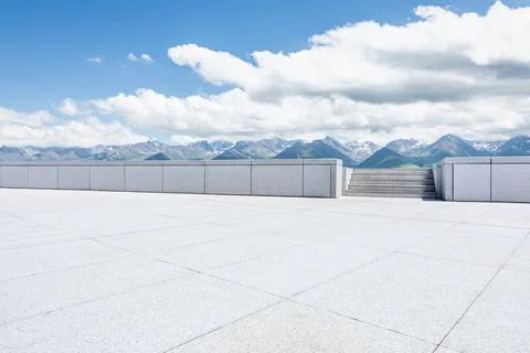 Empty square floor and mountains under blue sky. Stock Photos