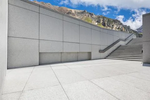 Empty square floor and mountains under blue sky. Stock Photos