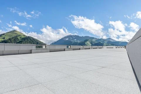 Empty square floor and mountains under blue sky. Stock Photos