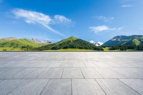 Empty square floor and mountains under blue sky. Stock Photos