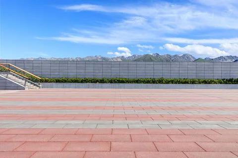 Empty square floor and mountains under blue sky. Stock Photos