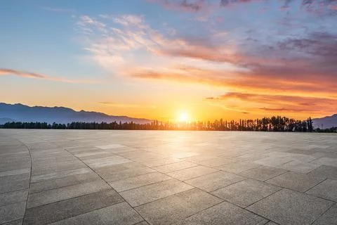 Empty square floor and mountains at sunrise. Stock Photos