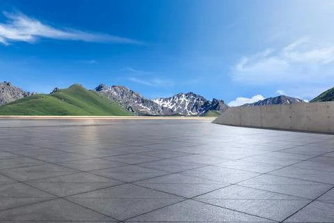 Empty square floor and mountains under blue sky. Stock Photos