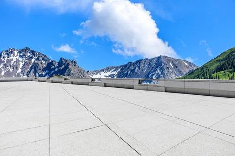Empty square floor and mountains under blue sky. Stock Photos