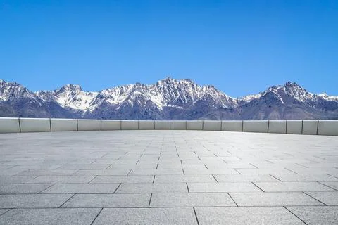 Empty square floor and mountains under blue sky. Stock Photos