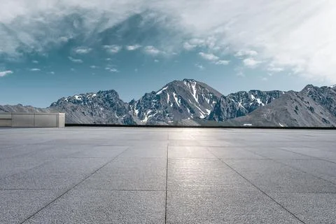 Empty square floor and mountains under blue sky. Stock Photos