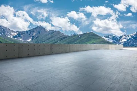 Empty square floor and mountains under blue sky. Stock Photos