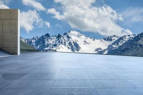 Empty square floor and mountains under blue sky. Stock Photos