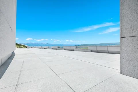 Empty square floor and mountains under blue sky. Stock Photos