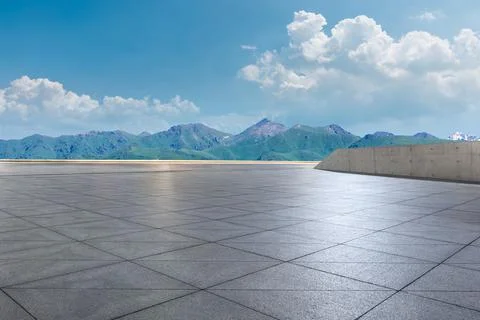 Empty square floor and mountains under blue sky. Stock Photos