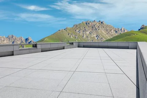 Empty square floor and mountains under blue sky. Stock Photos