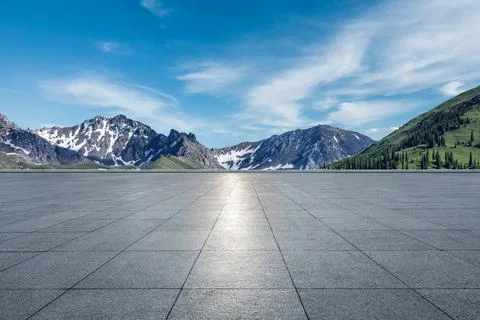 Empty square floor and mountains under blue sky. Stock Photos