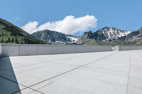 Empty square floor and mountains under blue sky. Stock Photos