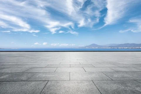 Empty square floor and river with mountains under blue sky. Stock Photos