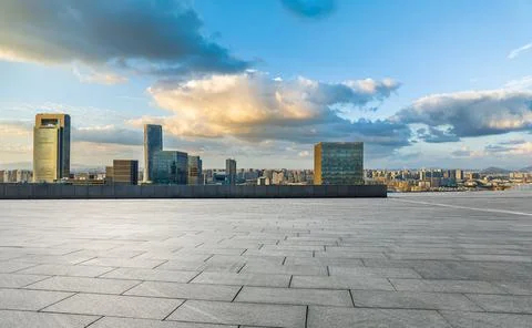 Empty square floors and modern city skyline with buildings at sunset Stock Photos