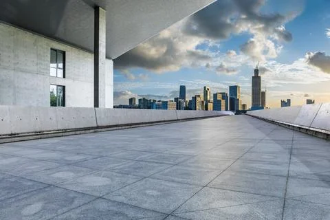 Empty square floors and modern city skyline with buildings at sunset Stock Photos