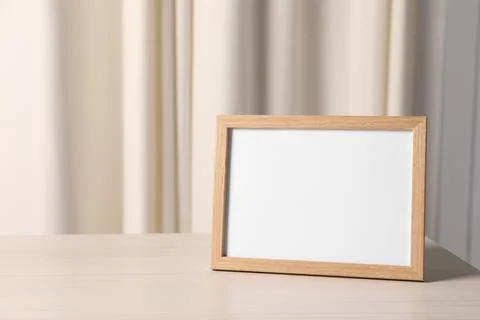 Empty square frame on white wooden table indoors, space for text Foto stock