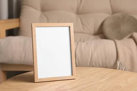 Empty square frame on wooden table indoors, space for text Foto stock