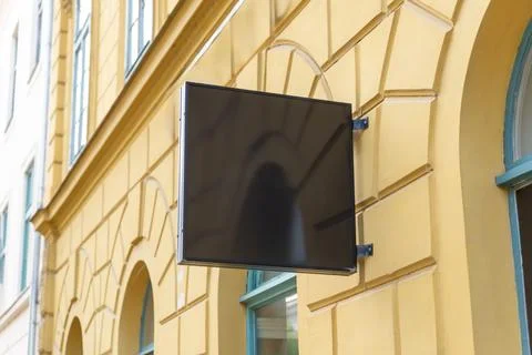 Empty square hanging sign attached to a historic urban facade, suitable for.. Stock Photos
