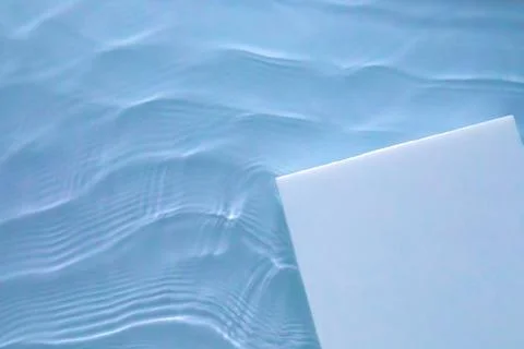 Empty square podium on transparent blue water background Stock Photos