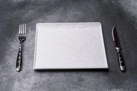 Empty square white plate on a gray moody background with copy space Foto stock