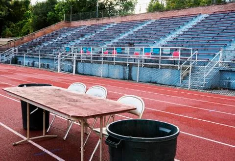 Empty stadium bleachers with table and chairs on track Stock Photos