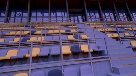 The empty stadium features stands adorned with yellow and gray seats, awaiting Stock Footage 306968713
