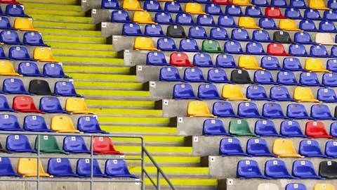 Empty stadium stands with colorful plastic seats, yellow stairs and concrete Stock Footage 340139038