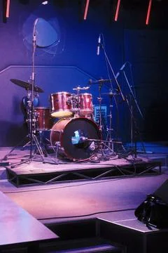 Empty stage drum kit under vivid blue and purple lights Stock Photos
