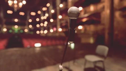An empty stage with a microphone and chairs Stock Illustration