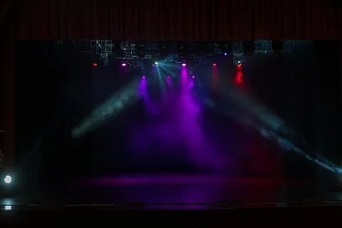 An empty stage of the theater, lit by spotlights and smoke Stock Photos
