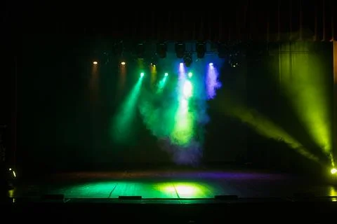 An empty stage of the theater, lit by spotlights and smoke Stock Photos