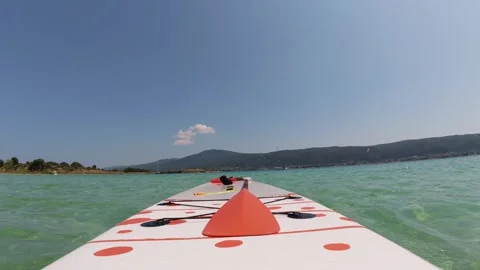 Empty stand-up paddleboard floating gently on turquoise waves. Calm sea, clear Stock Footage 313808756